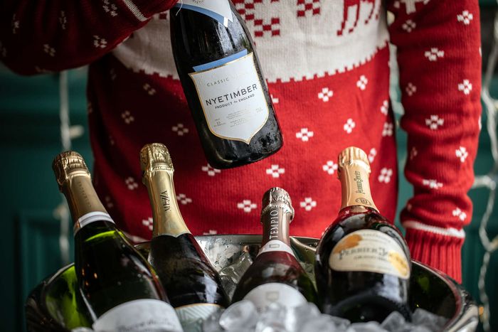 Bottles of Sparkling, Champagne & Prosecco with a person in a Christmas Jumper